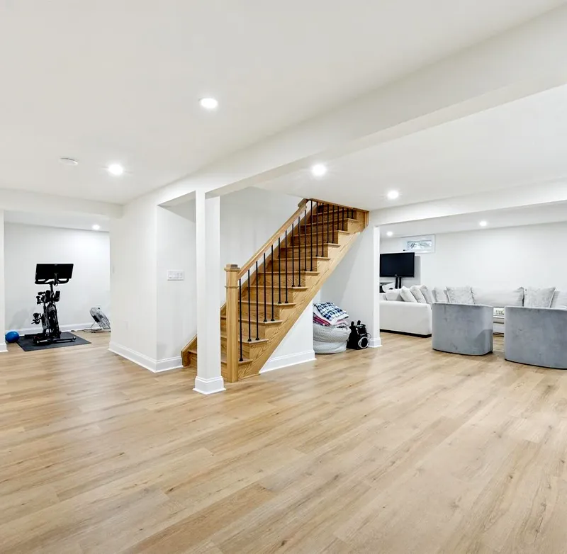 Finished basement family room with painted drywall and carpet, serving homeowners in Wellesley, MA