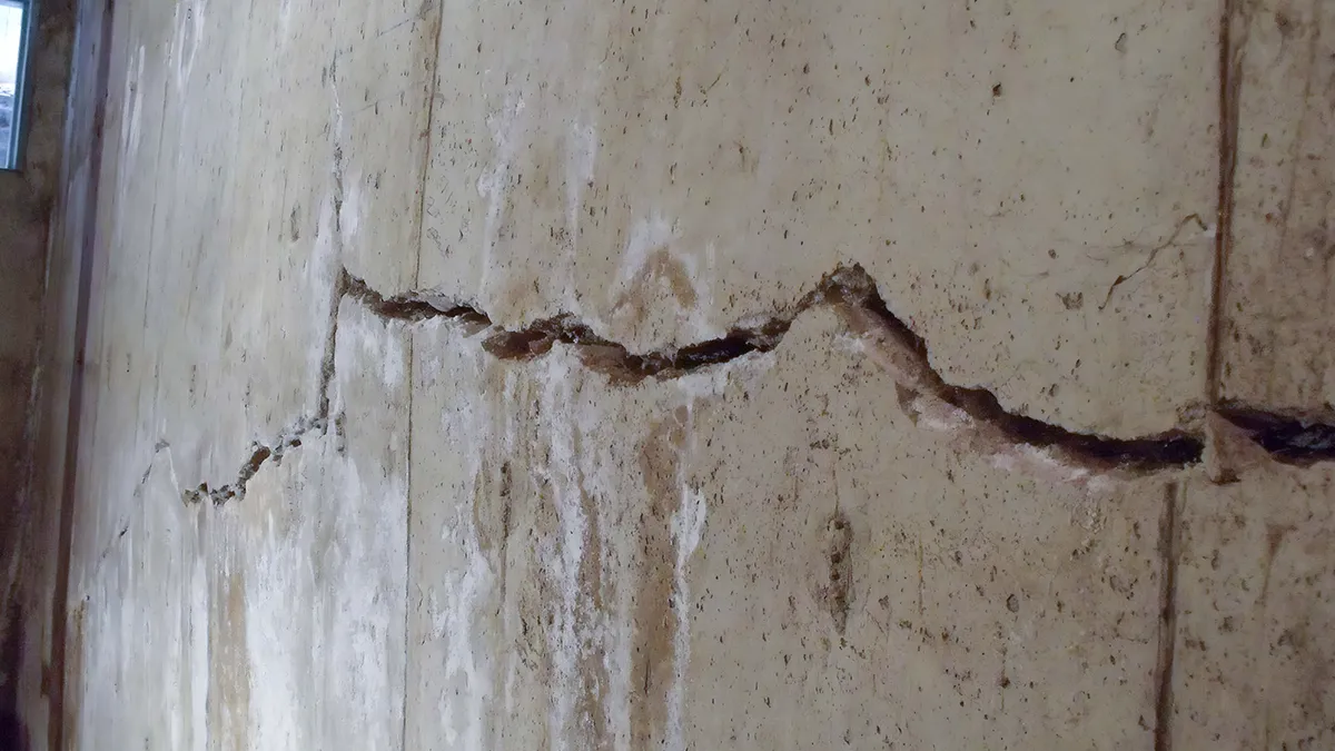 Thin vertical crack running down a poured concrete basement wall
